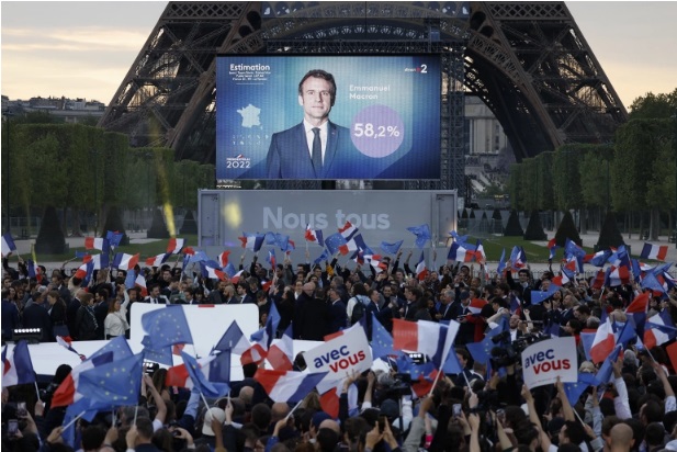 Macron supporters at the Champ de Mars in Paris react after the release of projected results [Ludovic Marin/AFP]